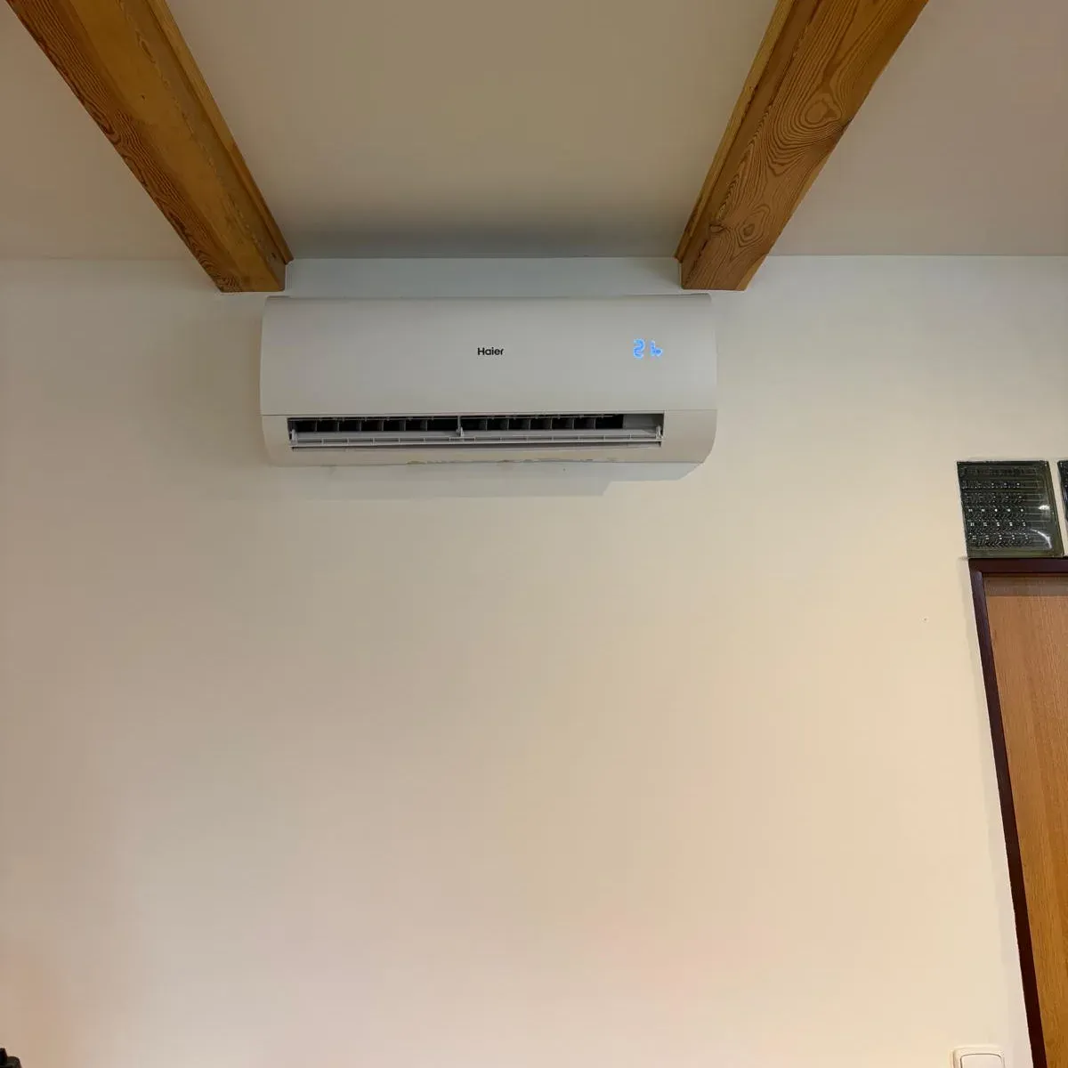 Vnitřní jednotka Haier Pearl Premium pod stropem mezi dřevěnými trámy